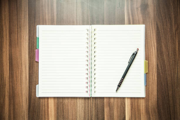 istock Pen and notepad on a wood background. 936796804