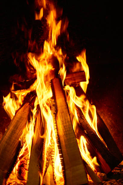 istock Burning firewood in the fireplace on a dark background. 936799002