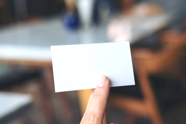 istock An image of a hand holding empty business card in modern cafe 936799172