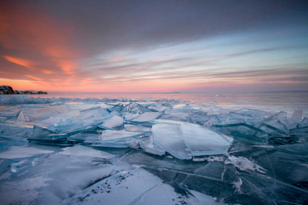 istock Lake Baikal at sunset, everything is covered with ice and snow, thick clear blue ice. Lake Baikal in the rays of the setting sun. Amazing place, UNESCO world heritage 936799322
