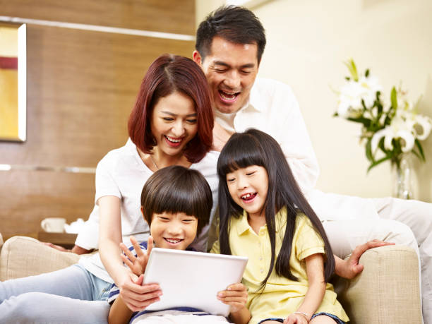 istock asian family using digital tablet together at home 936800466