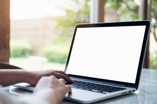 istock Mockup image of hand using laptop with blank white screen on vintage wooden table in cafe 936800544