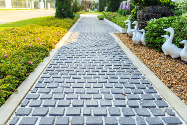 istock Pathway in a garden at front yard  with flowers tree and duck dolls. 936800936
