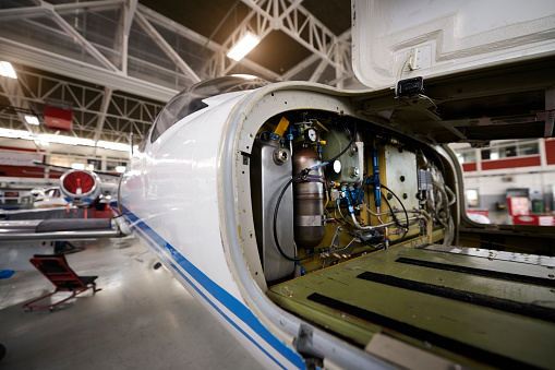 Private jet aircraft in the hangar open for regular maintenance service.