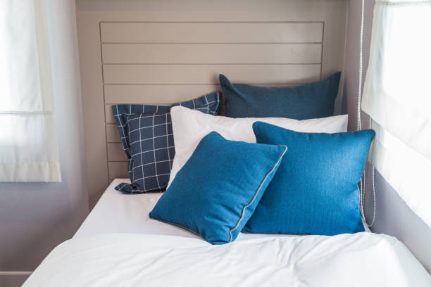 istock Many blue and white bedroom with warm light from window. 936801588