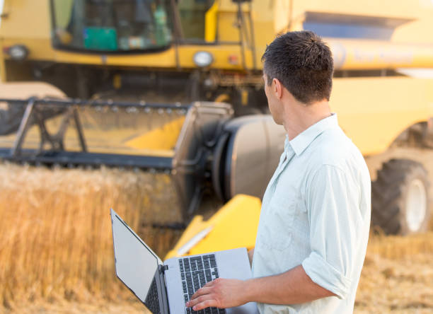 istock Engineer with laptop and combine harvester 936805688
