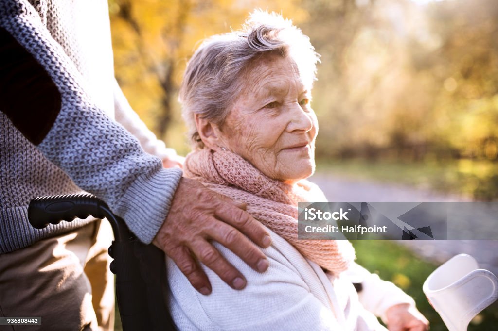 Senior homme et femme en fauteuil roulant dans la nature automne. - Photo de Troisième âge libre de droits