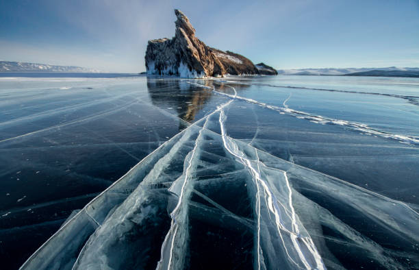 Photo of Lake Baikal is a frosty winter day. Largest fresh water lake. Lake Baikal is covered with ice and snow, strong cold and frost, thick clear blue ice. Icicles hang from the rocks. Amazing place heritage