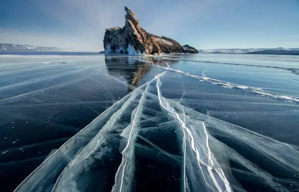 Lake Baikal is a frosty winter day. Largest fresh water lake. Lake Baikal is covered with ice and snow, strong cold and frost, thick clear blue ice. Icicles hang from the rocks. Amazing place heritage