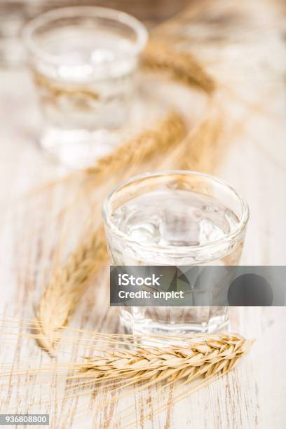 Clear Liquor With Cereal On Wooden Table Stock Photo - Download Image Now - Alcohol - Drink, Alternative Medicine, Aperitif