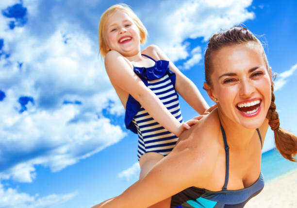 istock cheerful healthy mother and child on seashore having fun time 936812210
