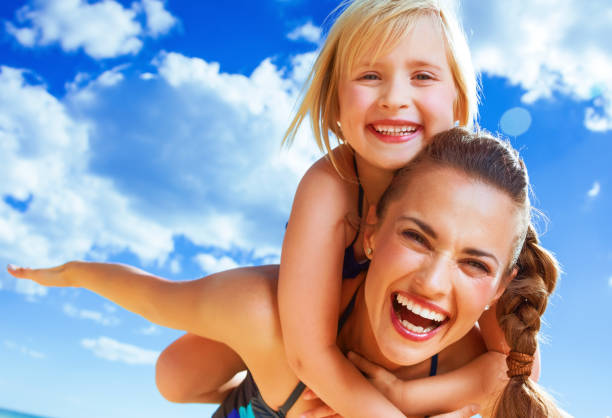 istock happy young mother and child on beach having fun time 936812228