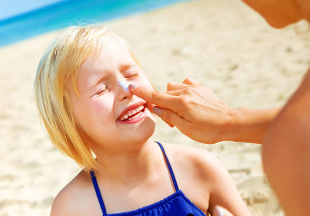 istock happy young mother and daughter on beach applying SPF 936812266