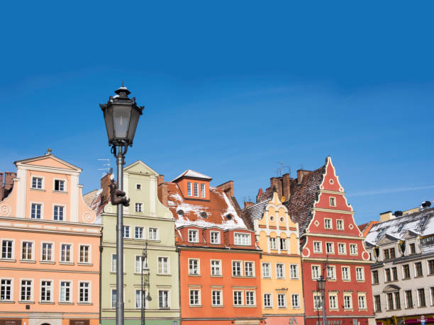 WROCLAW, POLAND - MARCH 18, 2018:   Wroclaw's old town is one of Europe's most colorful market squares and is the historical capital of Lower Silesia, Poland, Europe.  The dwarf statue clinging to the lamppost is one of 100s that can be found throughout the city and are considered a tourist attraction.