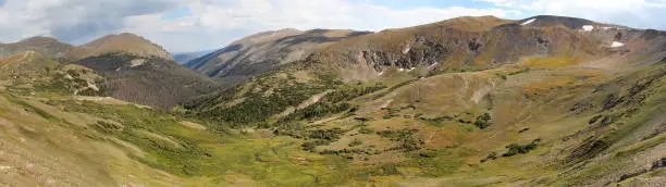 Panorama of Rocky Mountain National Park, Colorado, USA -- mountaintops with summer snow and valley.