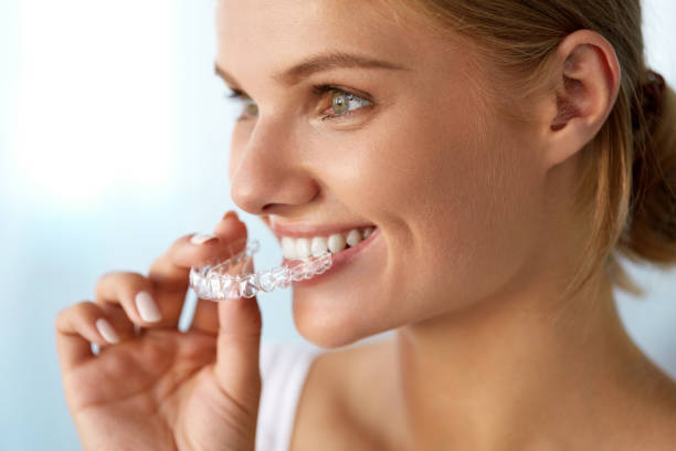 Smiling Woman With Beautiful Smile Using Invisible Teeth Trainer stock photo