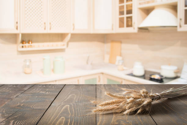 istock Blurred background. Wooden tabletop with wheat and defocused modern kitchen for display your products. 936821378