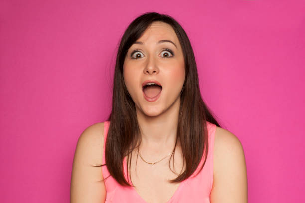 istock Young surprised woman on pink background 936821858