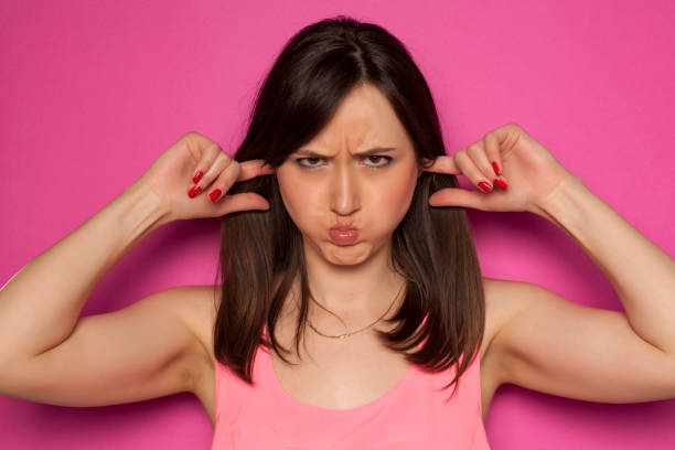 istock Young funny woman making silly faces on pink background 936821888