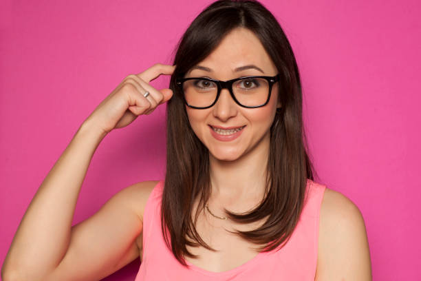 istock forgetful woman scratching her head on pink background 936821890