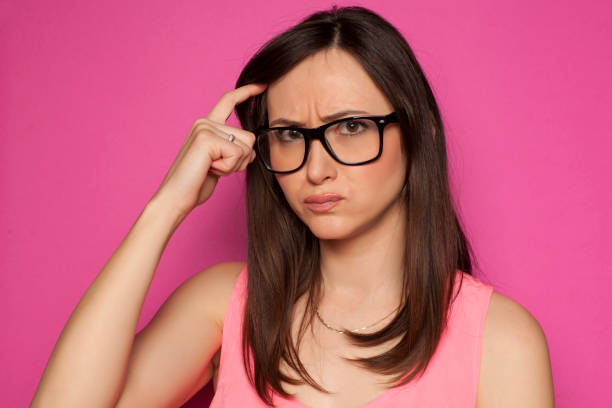 istock forgetful woman scratching her head on pink background 936821892