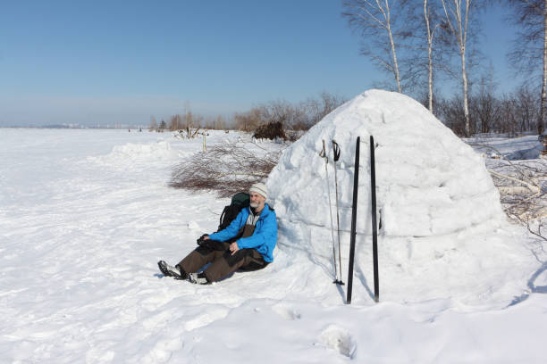 istock Man skier sitting by an igloo on a glade in the winter 936824988