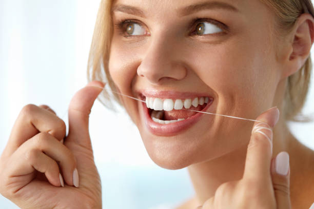 istock Teeth Care. Beautiful Smiling Woman Flossing Healthy White Teeth 936826012