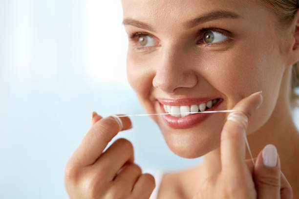 istock Teeth Care. Beautiful Smiling Woman Flossing Healthy White Teeth 936826250