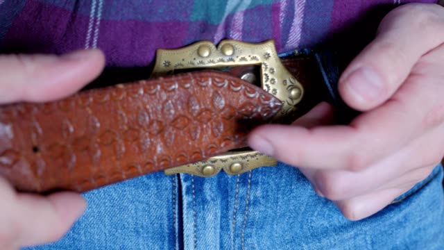 fastening the belt on trousers, decorative buckle
