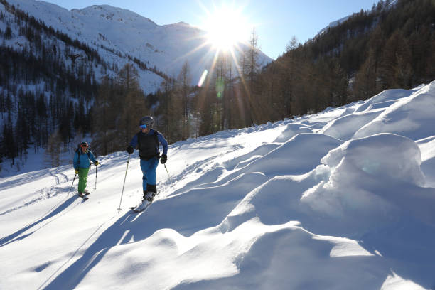 istock Backcountry skier and snowboarder ascend mountain slope 936829170