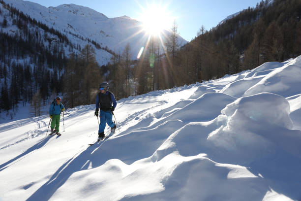 istock Backcountry skier and snowboarder ascend mountain slope 936829174