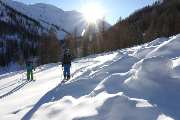 istock Backcountry skier and snowboarder ascend mountain slope 936829242