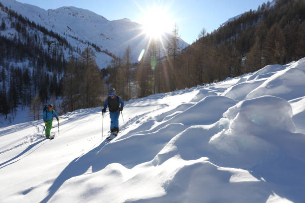 istock Backcountry skier and snowboarder ascend mountain slope 936829244
