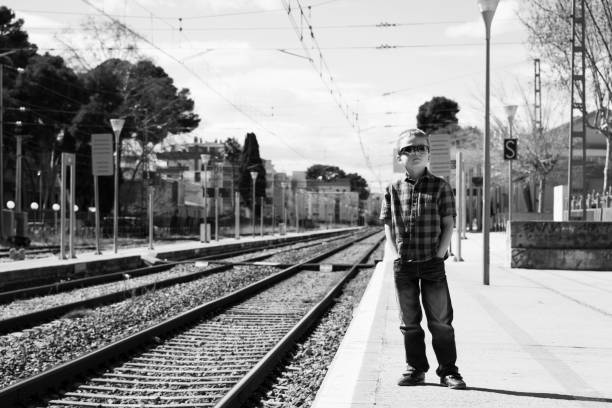 istock boy waiting for train at railway station 936829682