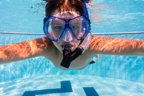 istock Boy in mask dive in swimming pool 936832698