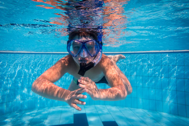 istock Boy in mask dive in swimming pool 936832748