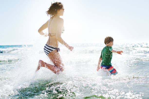 istock Mother and her son having fun in the sea 936834320