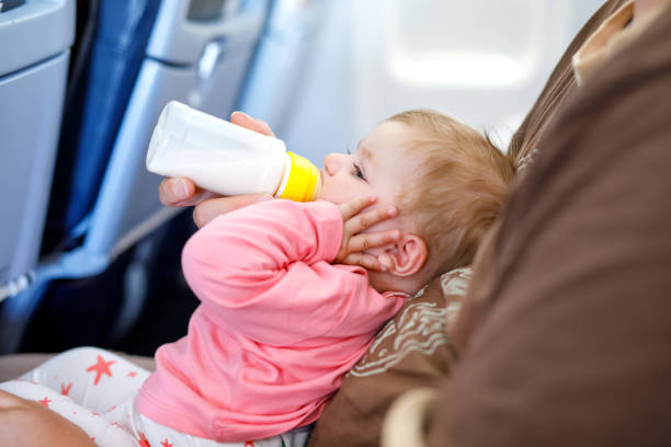 istock Father holding his baby daughter during flight on airplane going on vacations 936836754