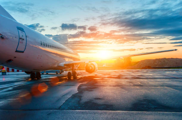 空・雲・太陽の夜明け空港に駐機している飛行機 - landing sunset airplane flying ストックフォトと画像