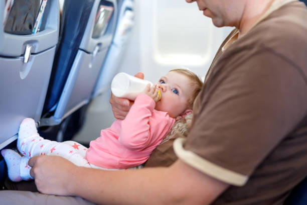 istock Father holding his baby daughter during flight on airplane going on vacations 936837766