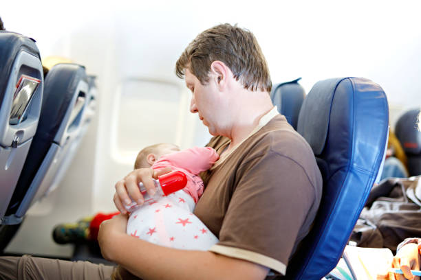 istock Young tired father and his baby daughter sleeping during flight on airplane going on vacations 936838062