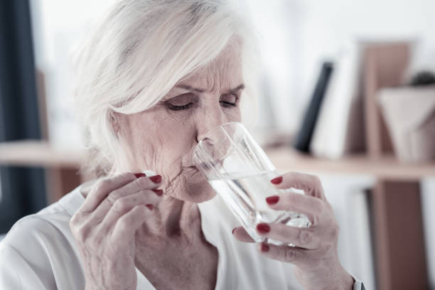 istock Serious mature woman drinking water 936841264