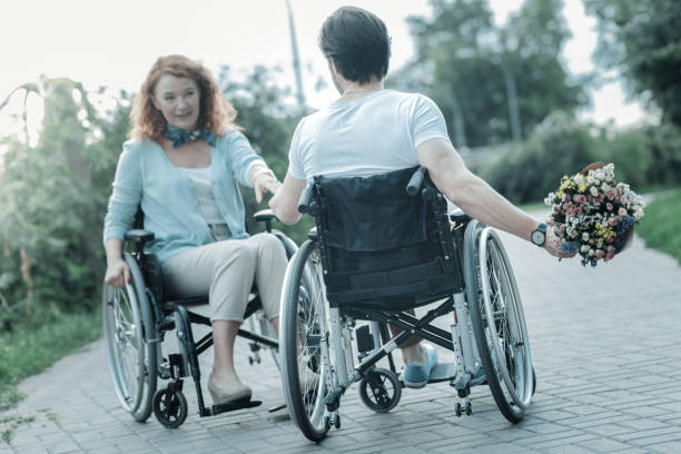 istock Back view of paralyzed man that holding flowers 936841742