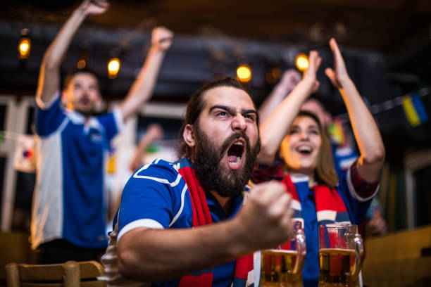 istock Happy couple celebrating while watching a football game in a bar 936841878