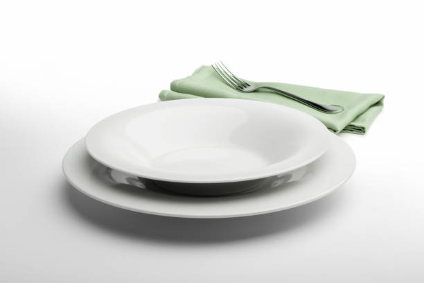 istock Empty round white plate and bowl with napkin and fork 936850272