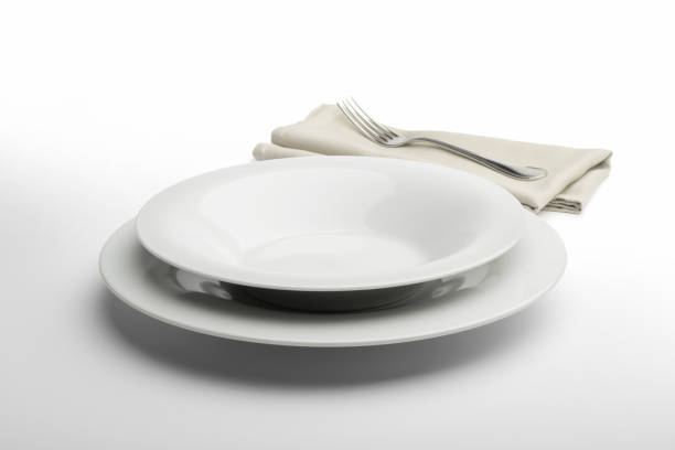istock Empty round white plate and bowl with napkin and fork 936850398
