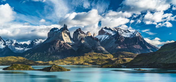 lago azul en un fondo de montañas nevadas y un cielo nublado torres del paine - patagonia fotografías e imágenes de stock