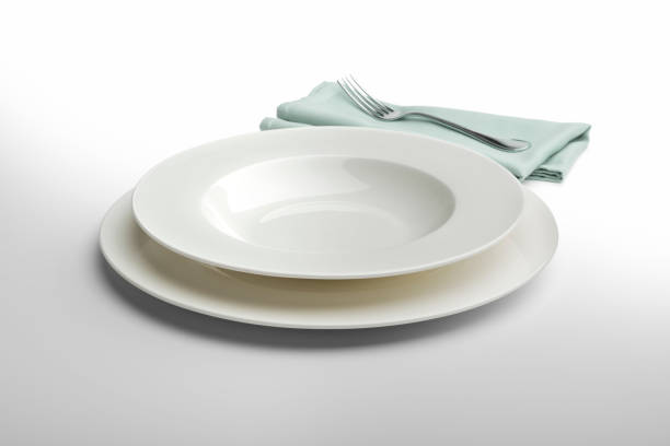 istock Empty round white plate and bowl with napkin and fork 936850614
