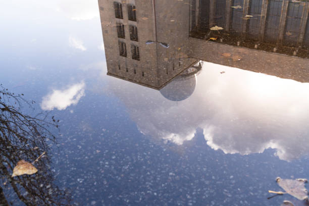 istock reflection of a building in a puddle with autumn leaves 936850850
