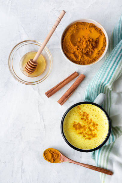 istock Turmeric latte (Golden Milk) with honey. Top view. 936857932